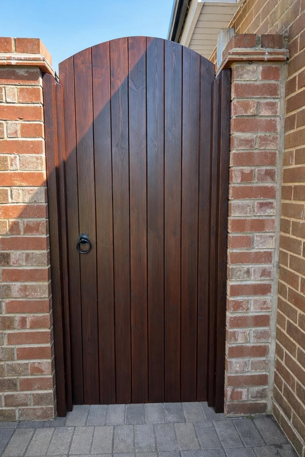 Dark stained timber side gate with diagonal brace and ironmongery