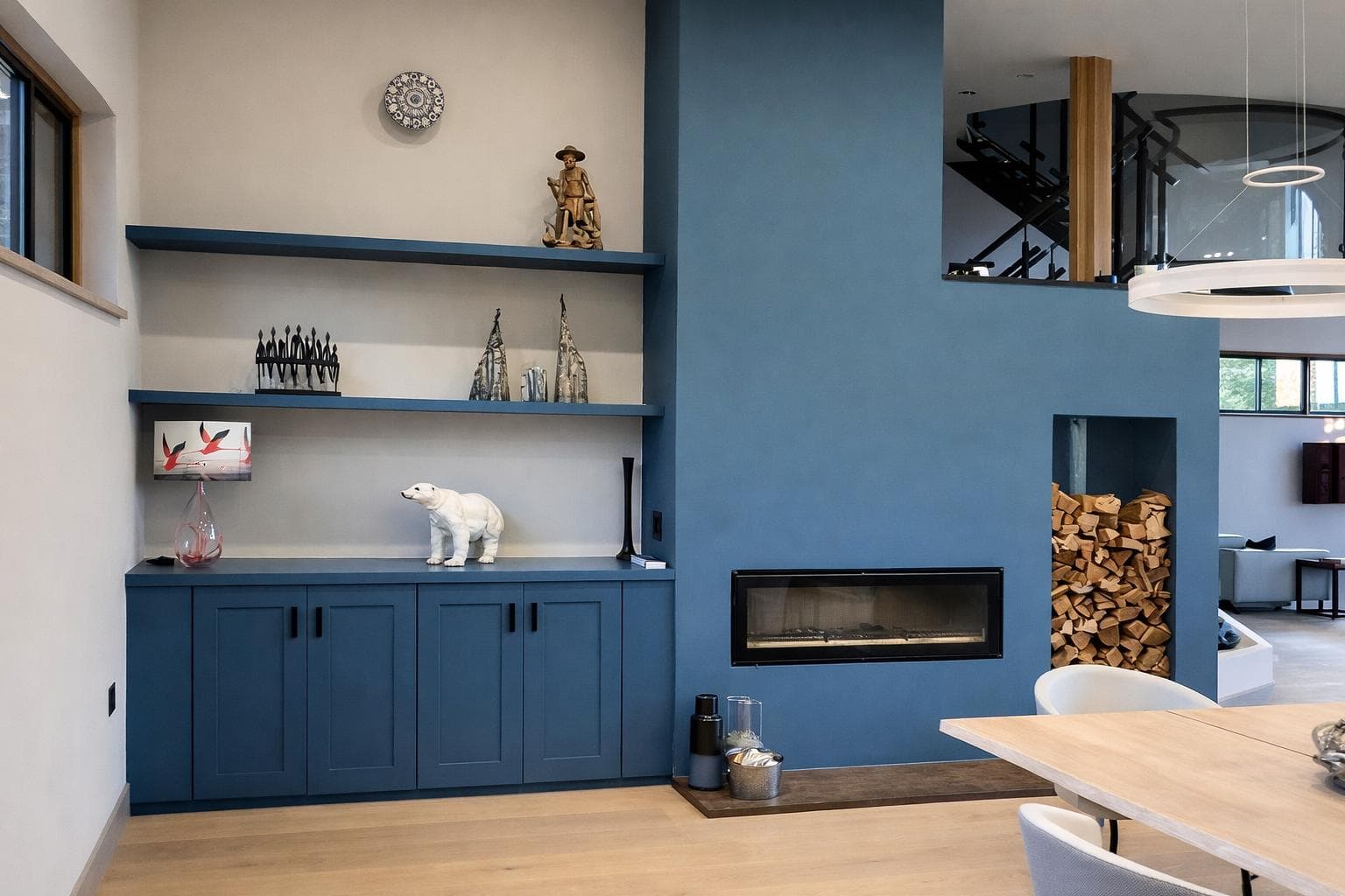 Blue painted alcove units with fireplace surround and integrated log store