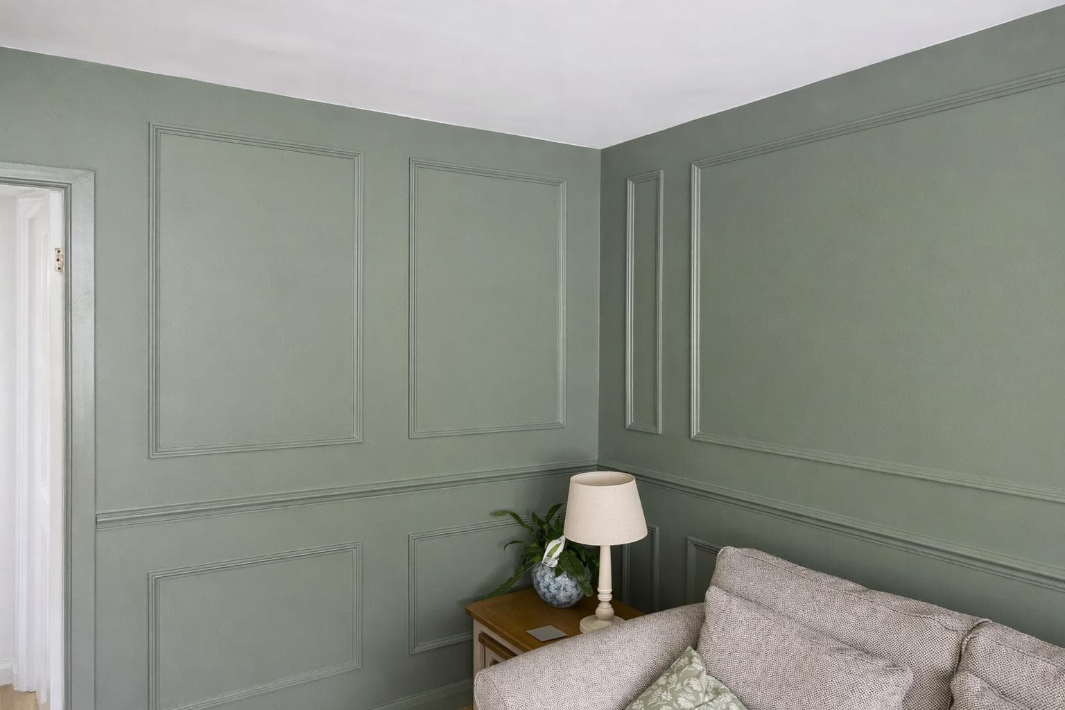 Sage green painted wall panelling with dado rail detailing